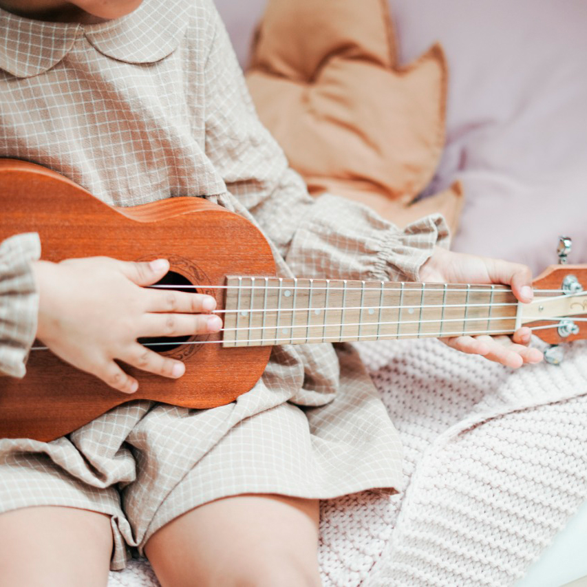 Nena tocando el ukelele
